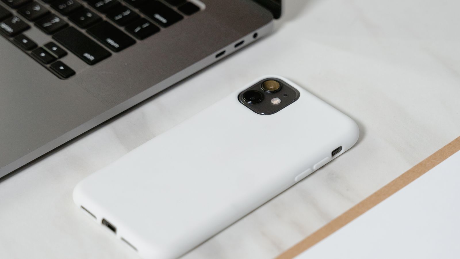 Smartphone e notebook sobre uma superfície de mármore