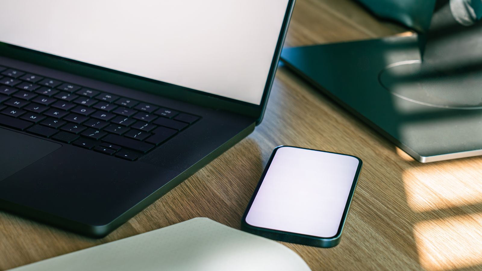 Notebook e smartphone organizados em uma mesa de escritório