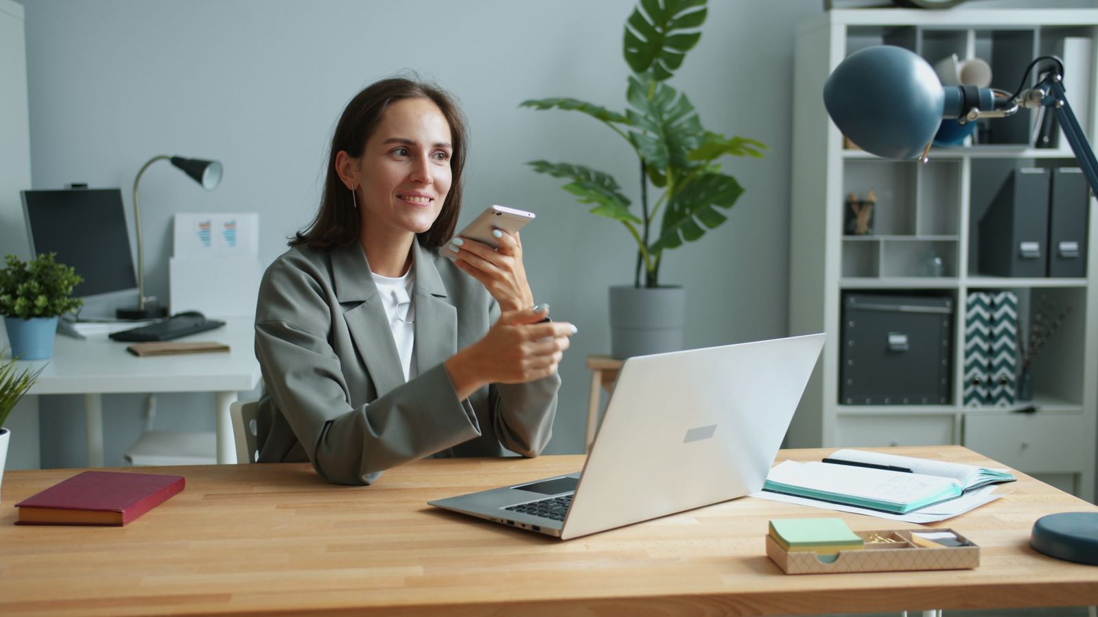 Profissional consultando o smartphone junto ao notebook